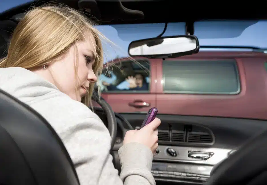 woman looking at phone while driving