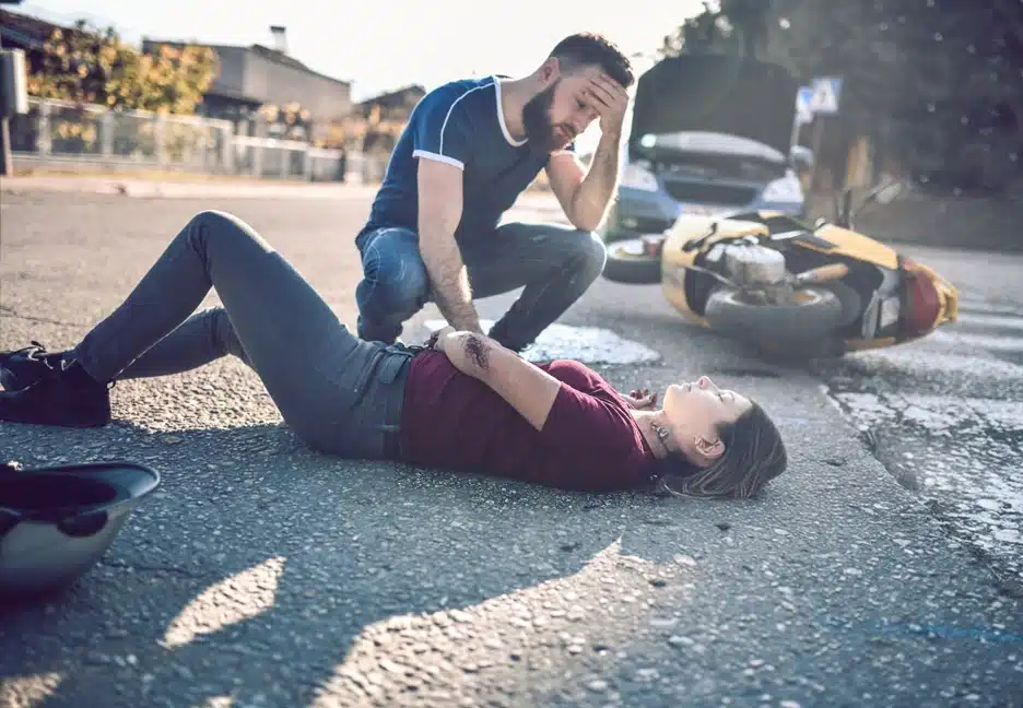 man helping woman who was injured in motorcycle accident