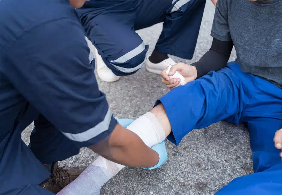 EMS attending to injured person's leg