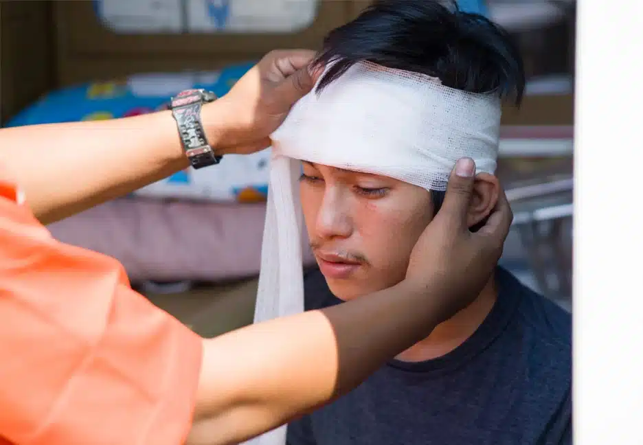 man getting head wrapped in gauze