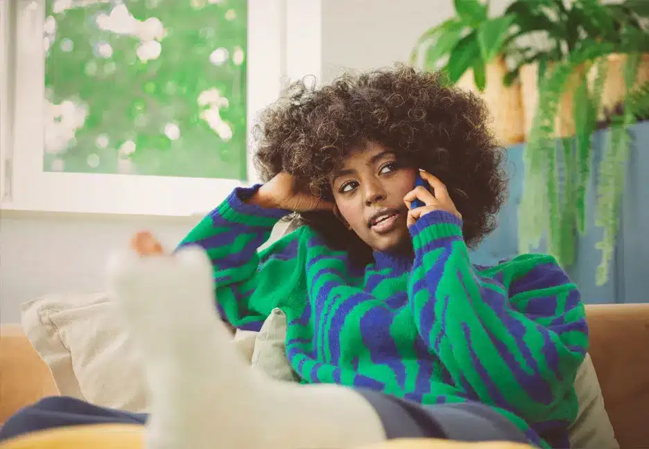 woman with injured leg on cell phone