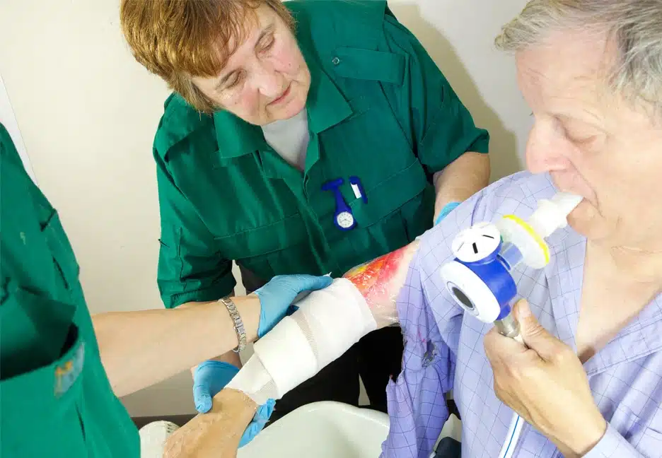 elderly woman with burn being treated by medical staff