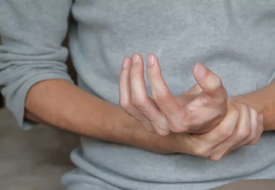 man holding his hand in discomfort