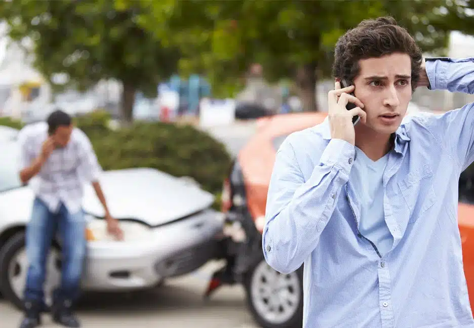 guy in car accident calling for help on phone