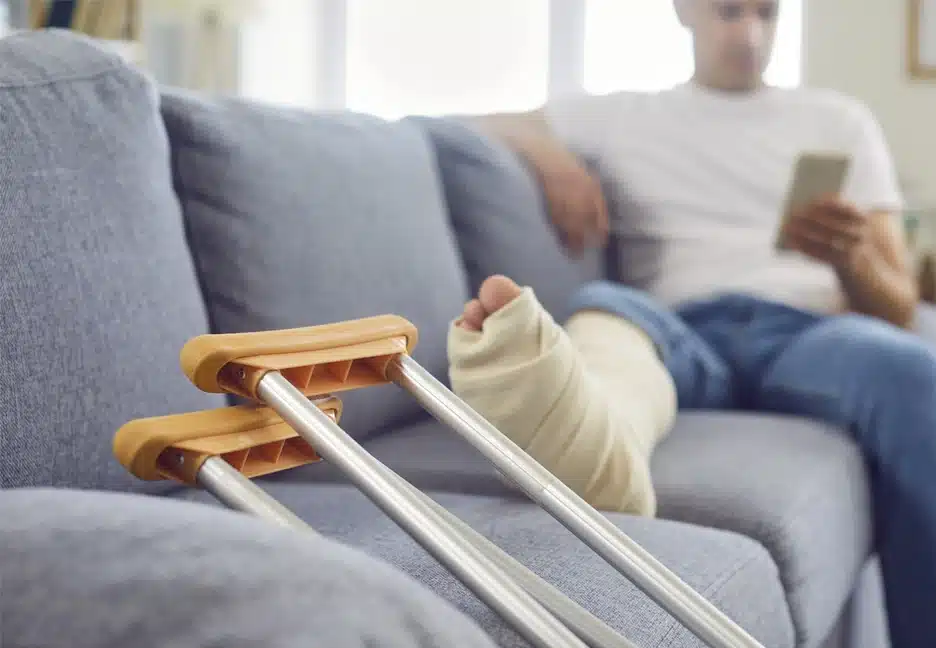 person with injured leg on couch using phone